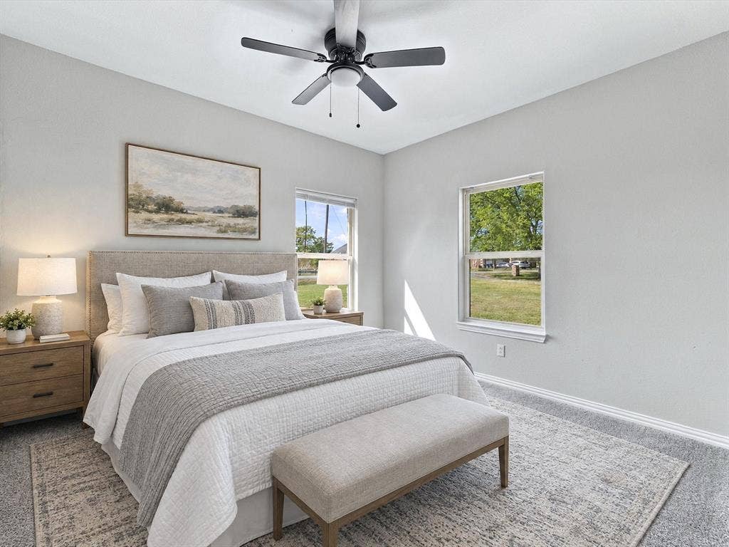 2312 Rogers Avenue, Lancaster, TX 75134 Neutral-toned room with plush carpeting, dual-pane windows, and a matte black ceiling fan with integrated lighting
