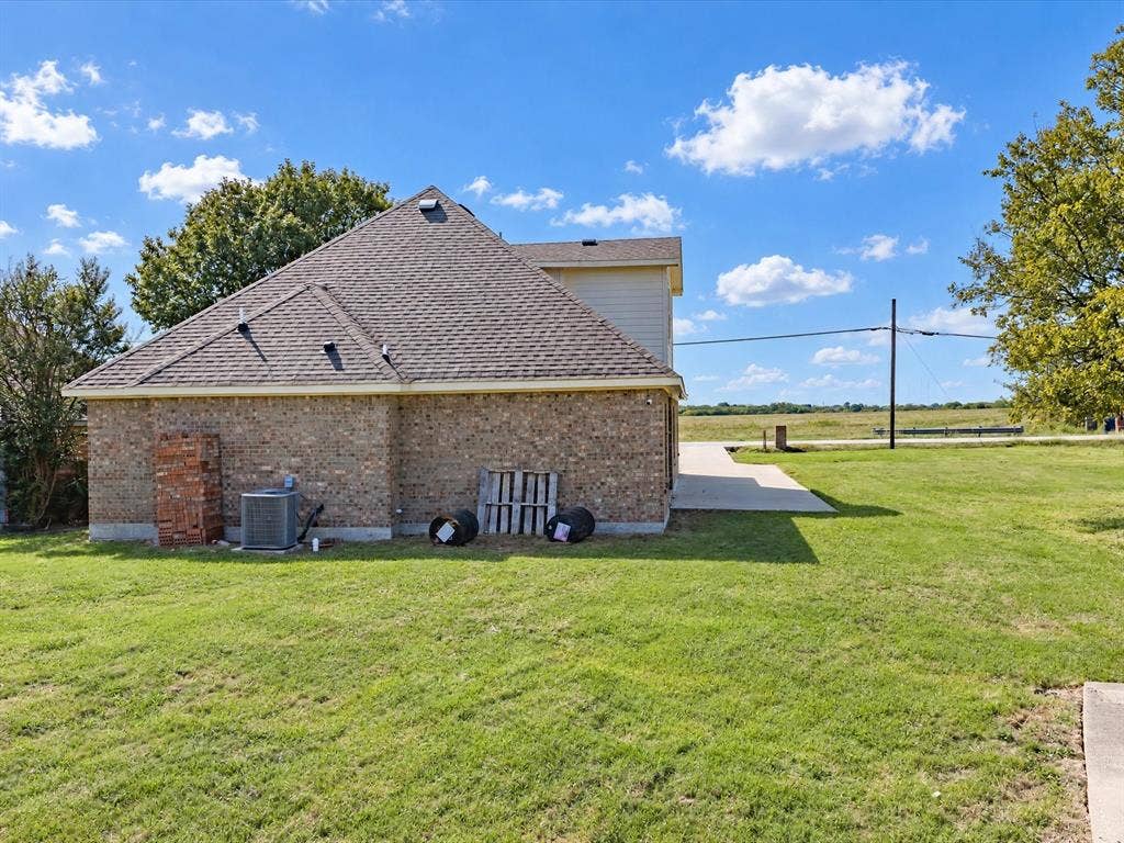 2312 Rogers Avenue, Lancaster, TX 75134 Exterior featuring a brick facade, composition shingle roof, concrete driveway, and expansive lawn area