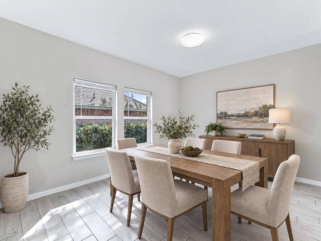 2312 Rogers Avenue, Lancaster, TX 75134 Virtually Staged Dining Area with neutral-toned walls, wood-finish tile flooring, and dual double-pane windows with integrated blinds