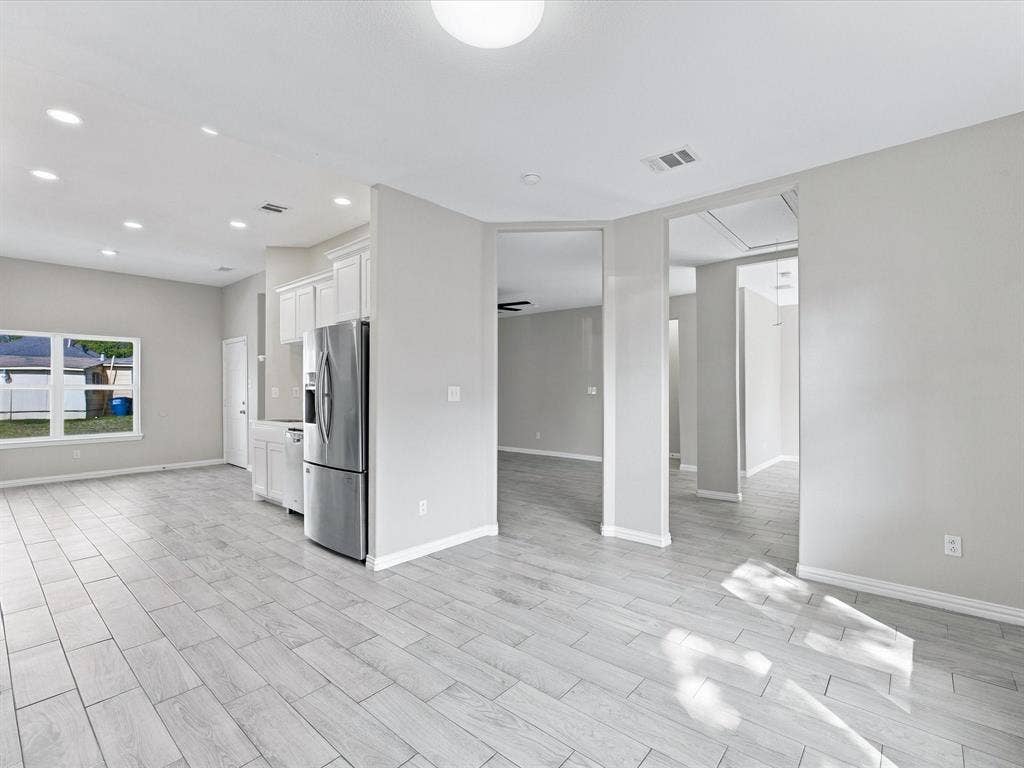2312 Rogers Avenue, Lancaster, TX 75134 Neutral interior featuring wood-finish tile flooring, recessed lighting, white cabinetry, and stainless steel appliances