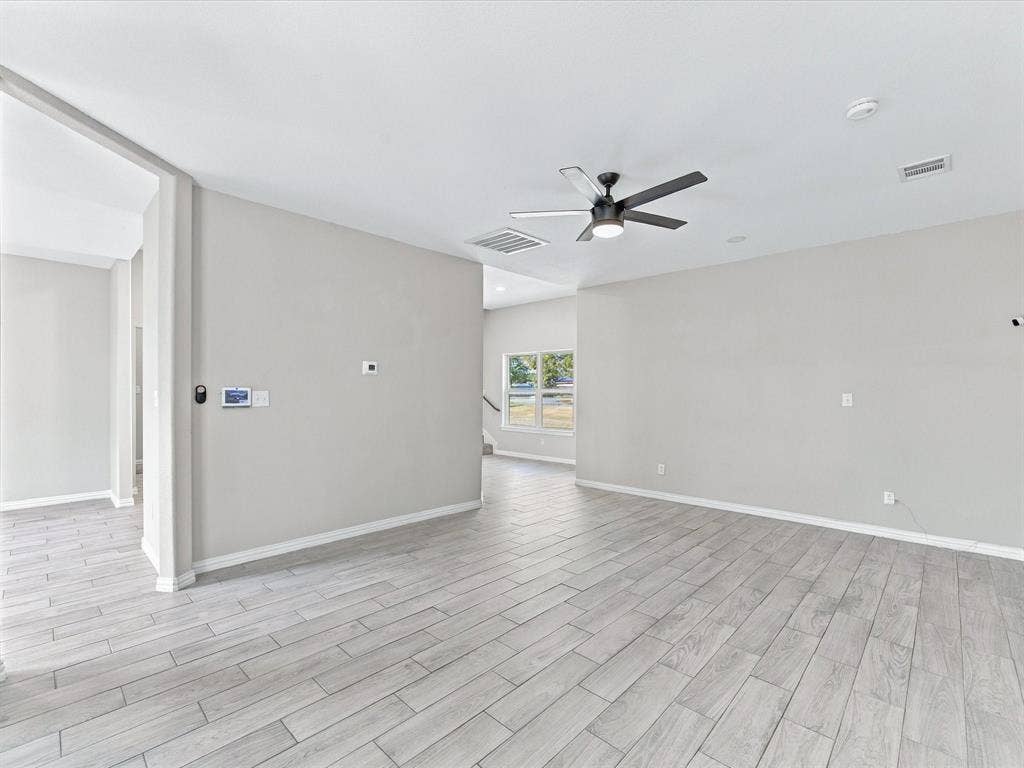 2312 Rogers Avenue, Lancaster, TX 75134 Interior space featuring wood-finish tile flooring, neutral wall paint, a multi-blade ceiling fan with integrated lighting, and recessed ceiling illumination