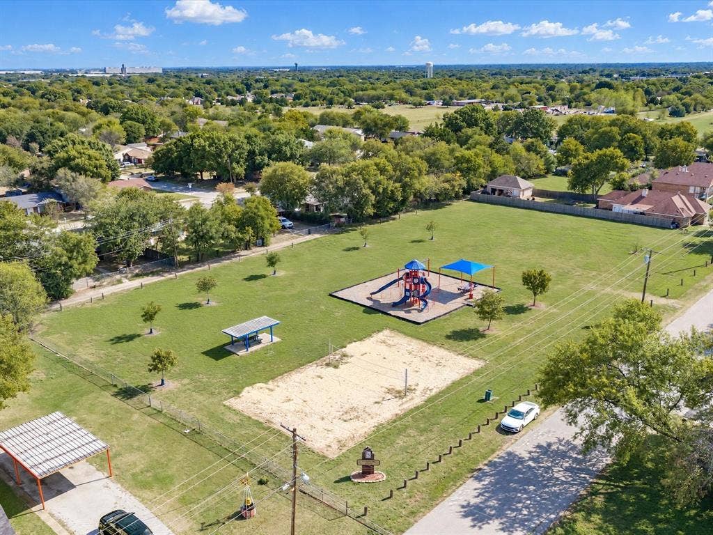 2312 Rogers Avenue, Lancaster, TX 75134 Expansive recreational area featuring a playground structure, sand volleyball court, shaded picnic pavilion, and mature trees across a manicured lawn
