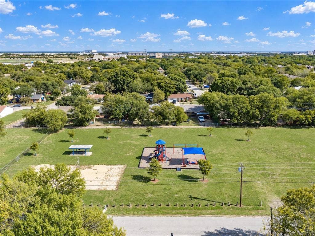 2312 Rogers Avenue, Lancaster, TX 75134 Expansive outdoor recreation space featuring a playground structure, sand volleyball court, and covered pavilion set within a landscaped lawn