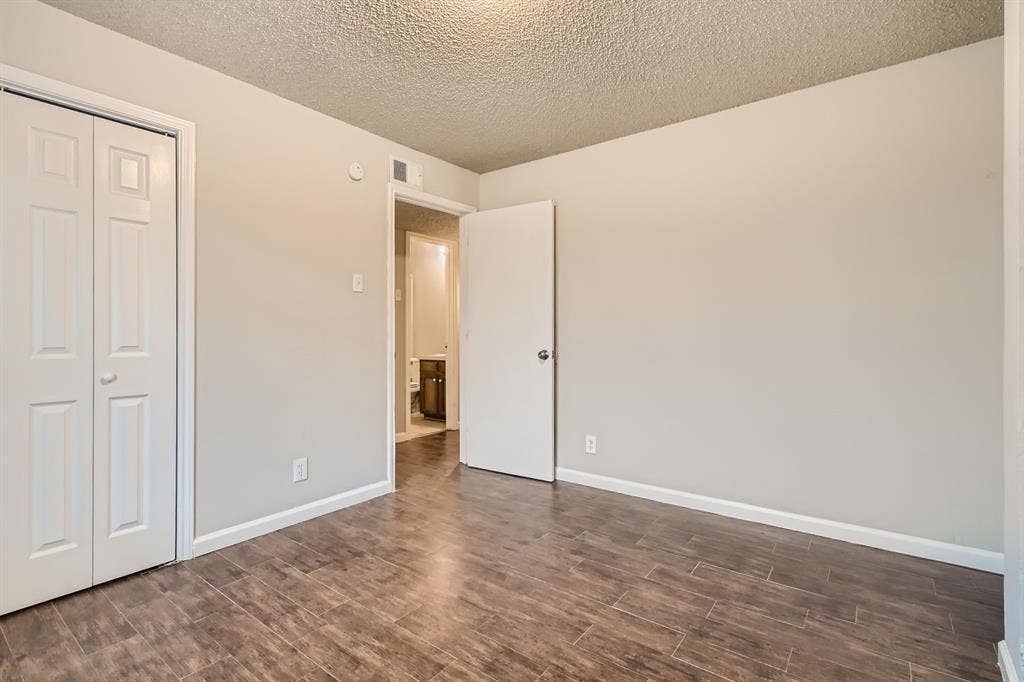 806 Prairie Creek Drive, Princeton, TX 75407 Interior space featuring wood-finish tile flooring, a dual-panel bi-fold closet door, and neutral wall tones
