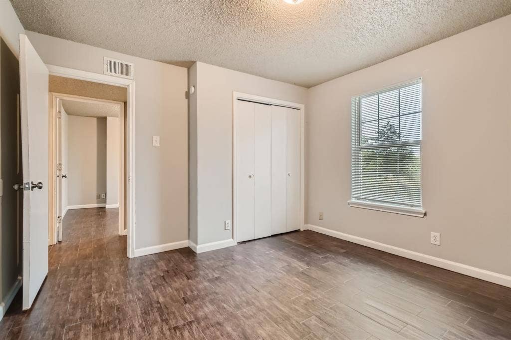 806 Prairie Creek Drive, Princeton, TX 75407 Wood-finish flooring, neutral wall tones, single-hung window with horizontal blinds, and a dual-panel closet door