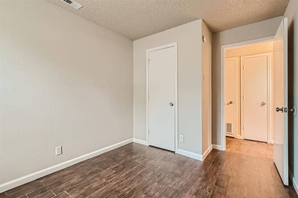 806 Prairie Creek Drive, Princeton, TX 75407 Interior space featuring neutral wall paint, wood-finish flooring, and multiple solid-core doors