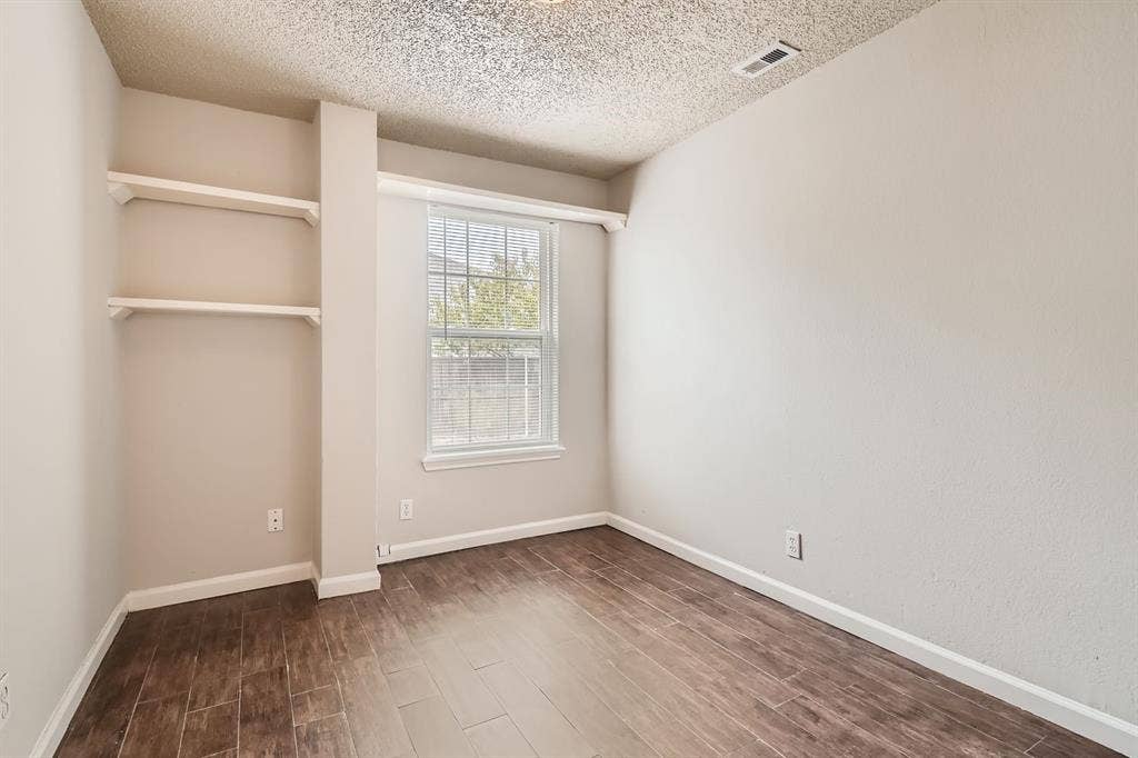 806 Prairie Creek Drive, Princeton, TX 75407 Room featuring wood-finish flooring, built-in shelving, neutral wall paint, and a single-pane window