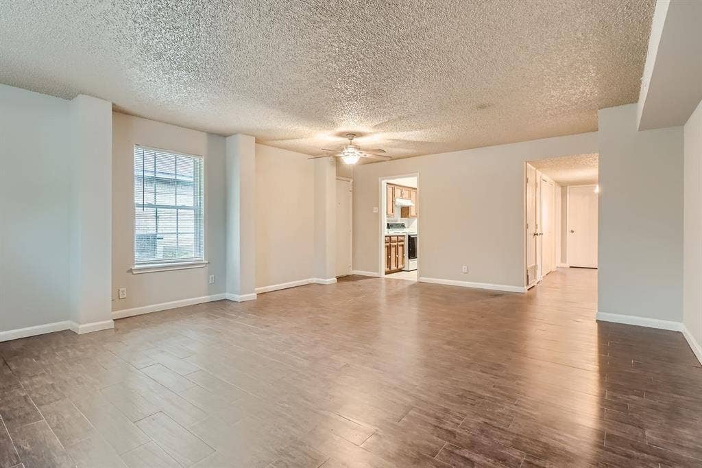 806 Prairie Creek Drive, Princeton, TX 75407 Open-concept room featuring wood-finish flooring, a ceiling fan with integrated lighting, and neutral wall tones