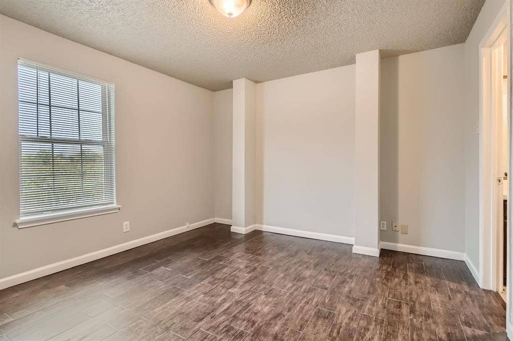 806 Prairie Creek Drive, Princeton, TX 75407 Room featuring wood-finish tile flooring, textured ceiling, flush-mount lighting, and a multi-pane window