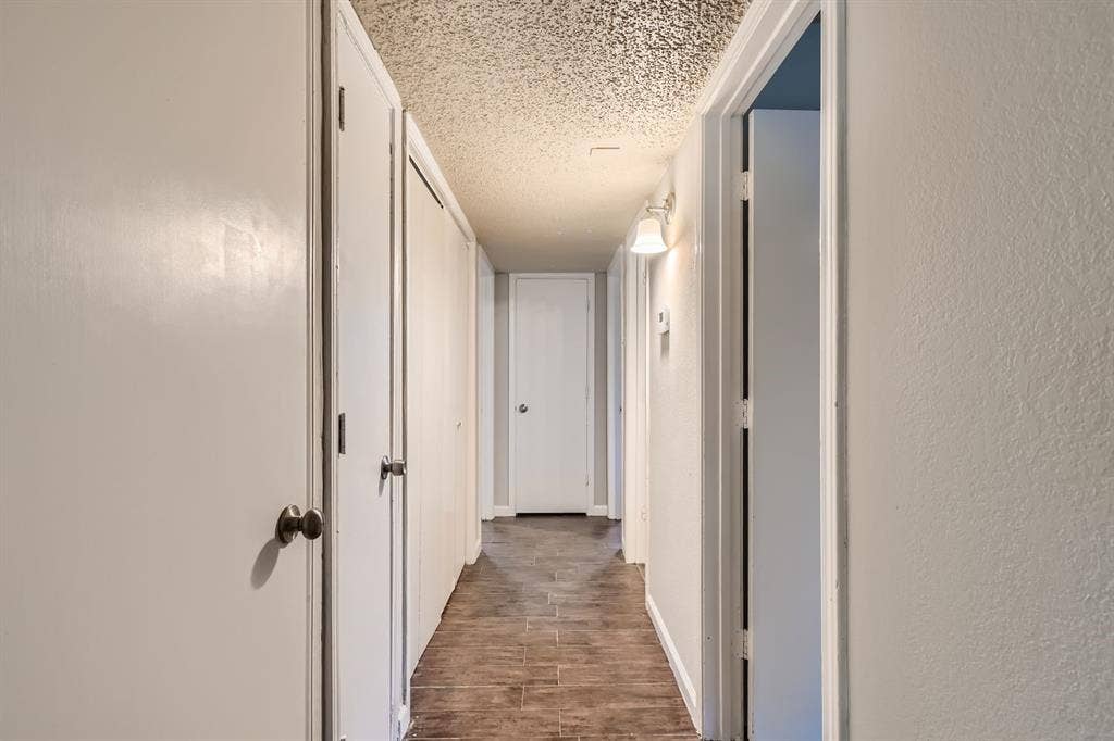 806 Prairie Creek Drive, Princeton, TX 75407 Hallway featuring tile flooring, multiple interior doors, and a wall-mounted light fixture