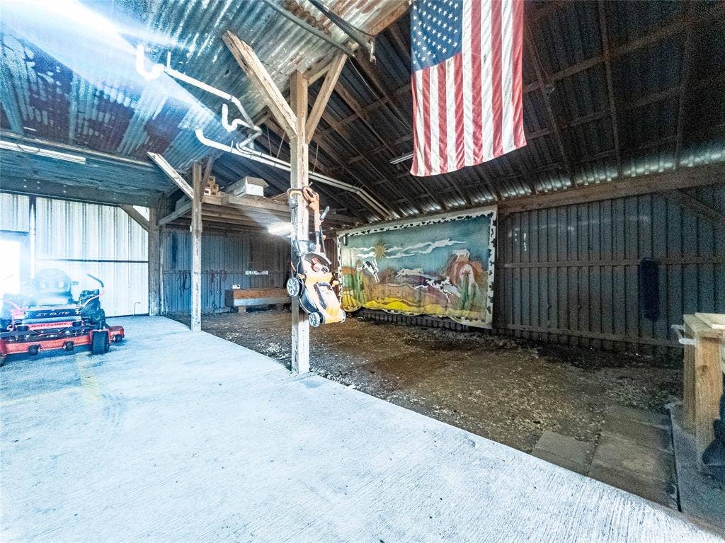 1154 Outlaw Trail, Wolfe City, TX 75496 Open-bay structure featuring a corrugated metal roof, timber frame construction, concrete flooring, and vertical wall paneling