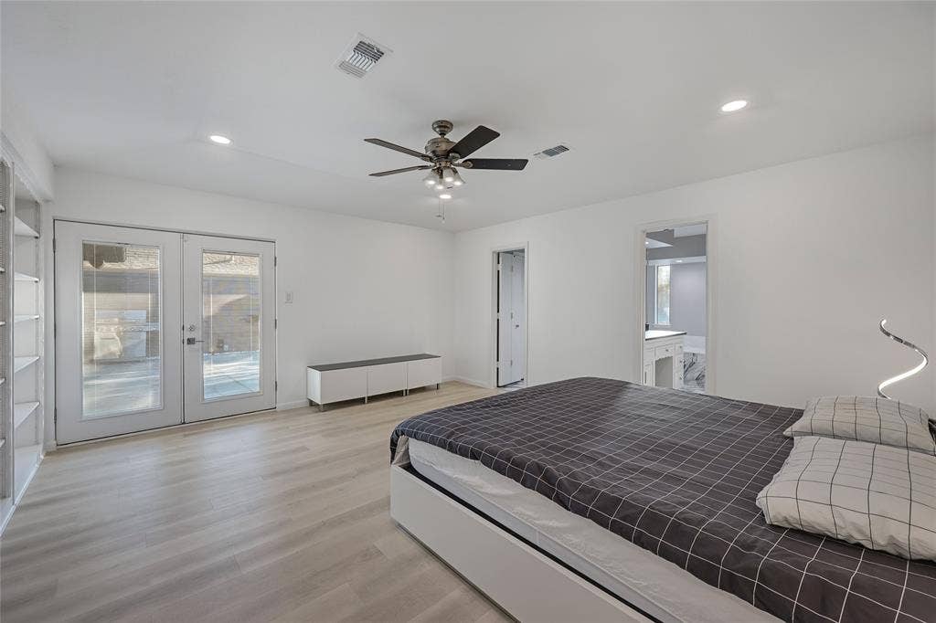 Interior space featuring light wood-finish flooring, recessed lighting, a ceiling fan with integrated light kit, built-in shelving, and white-framed glass French doors