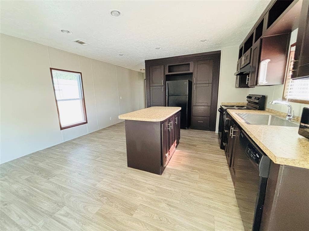 14311 Skyfrost Drive, #116, Dallas, TX 75253 Kitchen featuring dark-toned cabinetry, a center island, stone-finish countertops, recessed lighting, and wood-finish flooring