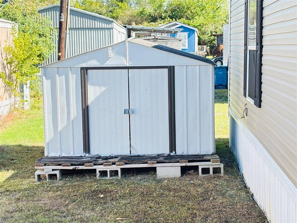 14311 Skyfrost Drive, #116, Dallas, TX 75253 Metal storage shed featuring double-door entry and a foundation constructed of concrete blocks and wood platform