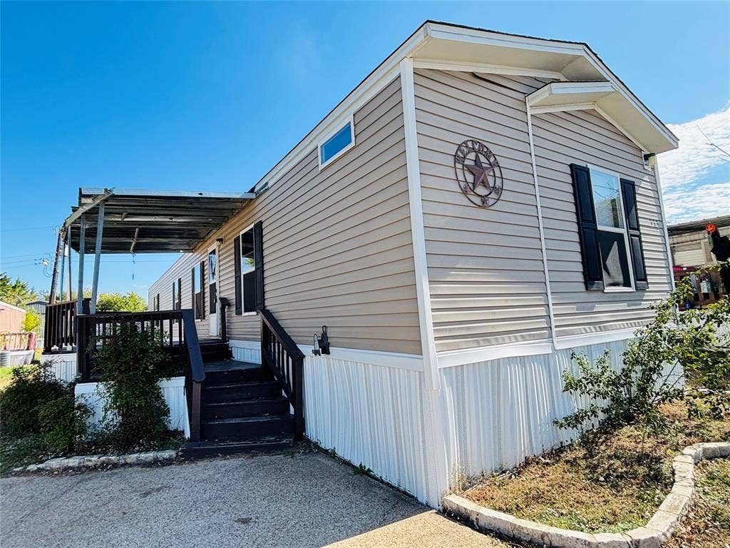 14311 Skyfrost Drive, #116, Dallas, TX 75253 Exterior featuring horizontal siding, dark-toned shutters, a covered porch with metal roofing, stairs with railing, and stone-bordered landscaping