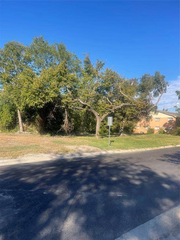 Cleared lot featuring mature trees and established grass landscaping