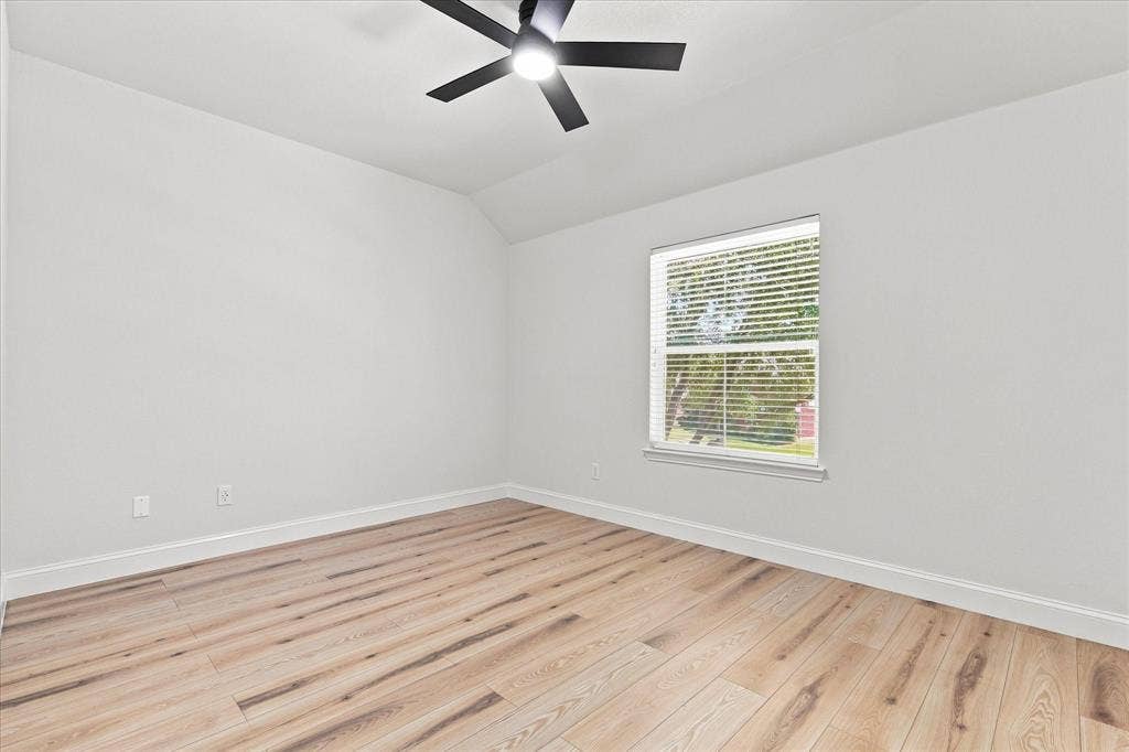 4421 Red Barn, Richardson, TX 75082 Room featuring wood-finish flooring, vaulted ceiling, and a matte black ceiling fan with an integrated light fixture