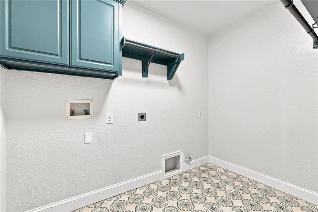 4421 Red Barn, Richardson, TX 75082 Utility room featuring blue wall-mounted cabinetry, integrated hanging rods, and patterned tile flooring