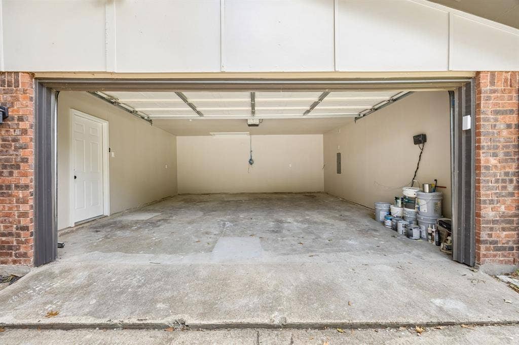 1213 Lombardy Drive, Plano, TX 75023 An expansive garage offers abundant room for vehicle parking, storage, and workspace possibilities. The wide garage opening provides convenient access, while the durable concrete floor and dedicated side entry add everyday functionality. With generous interior space and room to organize equipment or seasonal belongings, this area offers versatility beyond traditional parking.