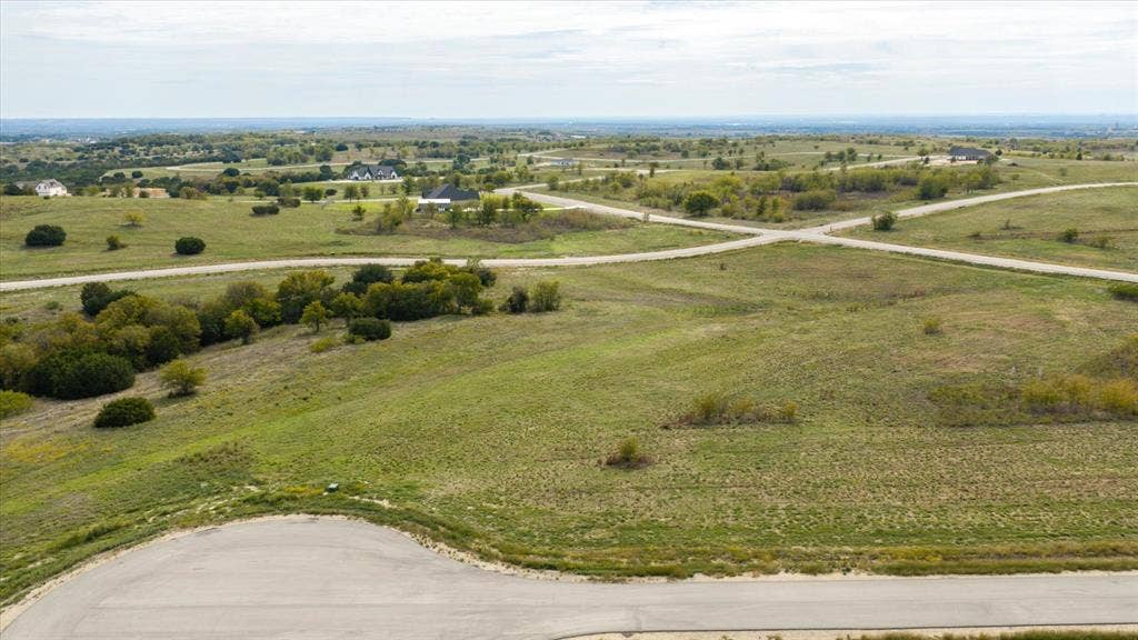 3337 Bounty Drive, Cresson, TX 76035 Expansive undeveloped land featuring rolling terrain, clusters of mature trees, paved road access, and a panoramic horizon