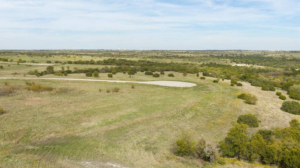 3337 Bounty Drive, Cresson, TX 76035 Expansive acreage featuring rolling terrain, native grasses, scattered mature trees, and a paved cul-de-sac