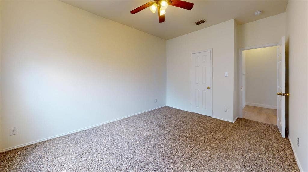 10514 Greenbriar Lane, Rowlett, TX 75089 Interior room featuring neutral wall paint, carpeted flooring, a six-panel door, and a ceiling fan with integrated lighting
