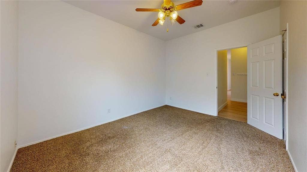 10514 Greenbriar Lane, Rowlett, TX 75089 Neutral-toned interior space featuring carpeted flooring, a ceiling fan with integrated lighting, and a six-panel interior door