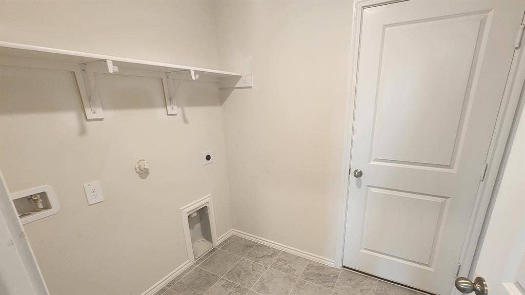 Integrated shelving system, white interior door, tiled flooring, neutral wall tones, and utility hookups