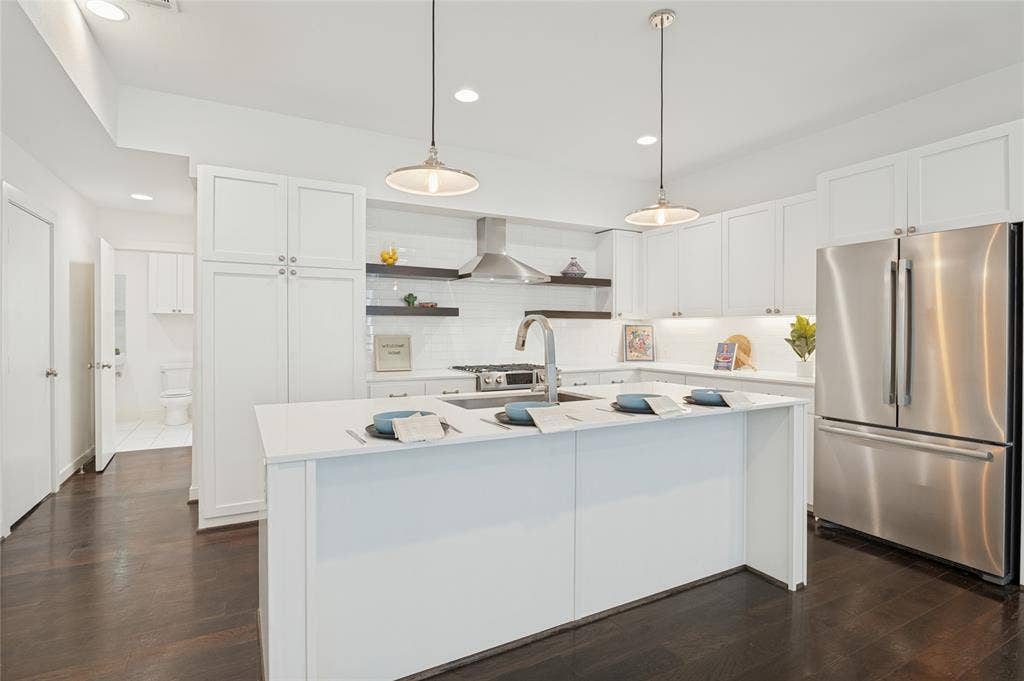 614 Finley Court, Dallas, TX 75208 Kitchen featuring white cabinetry, quartz countertops, stainless steel appliances, dark wood-finish flooring, and dual hanging pendant lights