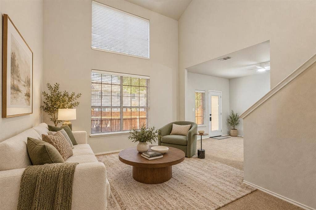 Vaulted ceilings, expansive stacked windows, neutral wall palette, and carpeted flooring