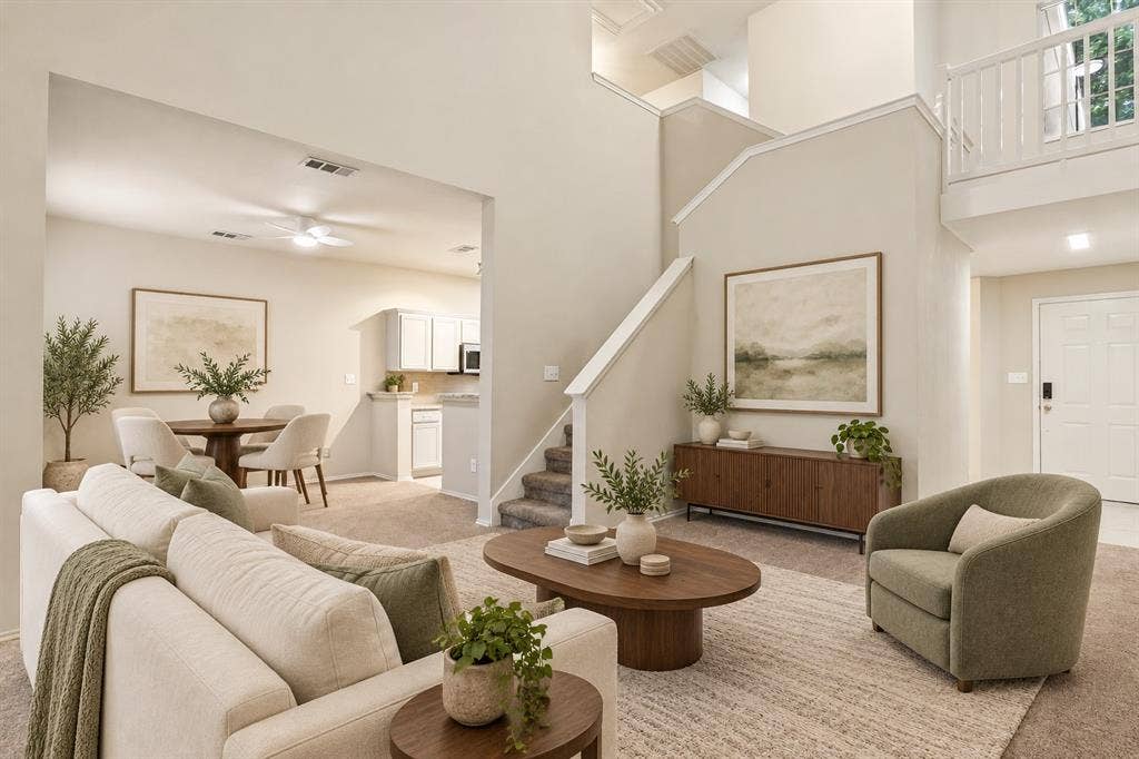 Vaulted ceilings, open-concept floor plan, second-story landing with balcony railing, and carpeted staircase