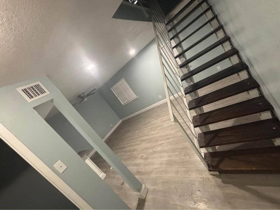 301 Rolston Road, #307-103, Irving, TX 75060 Open-tread staircase with metal railing, wood-finish flooring, and recessed ceiling lighting