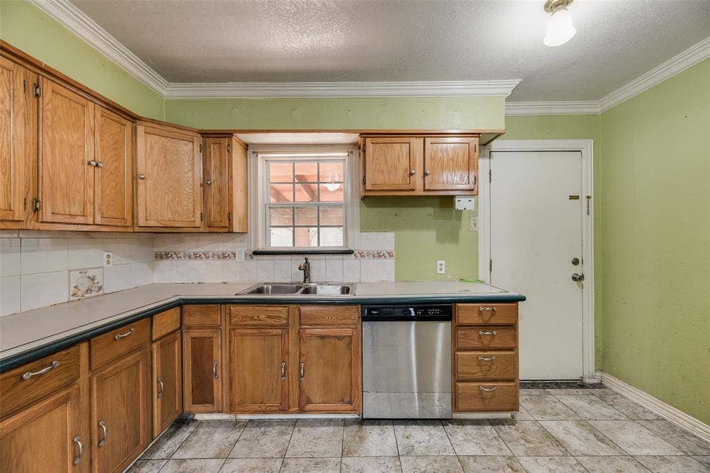 1572 Gillette Circle, Dallas, TX 75217 Kitchen featuring natural wood cabinetry, stainless steel dishwasher, dual-basin stainless steel sink, tiled backsplash, and stone-finish floor tiling