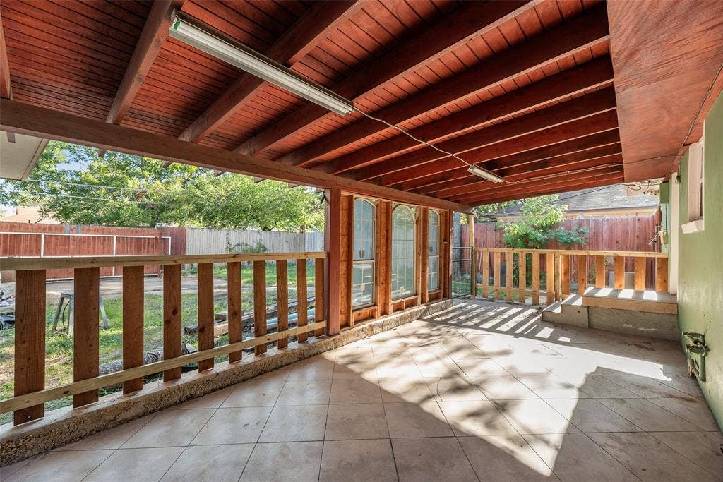 1572 Gillette Circle, Dallas, TX 75217 Covered patio featuring a timber-beamed ceiling, tile flooring, and wood railing