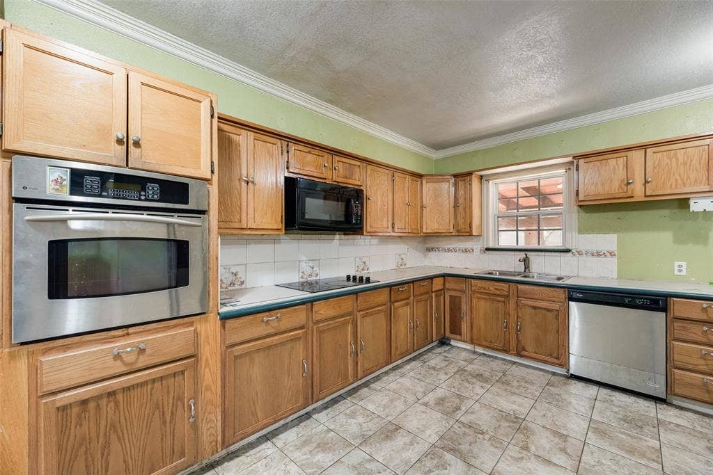 1572 Gillette Circle, Dallas, TX 75217 Kitchen featuring light-finish wood cabinetry, stainless steel built-in oven, integrated microwave, stainless steel dishwasher, and ceramic tile flooring