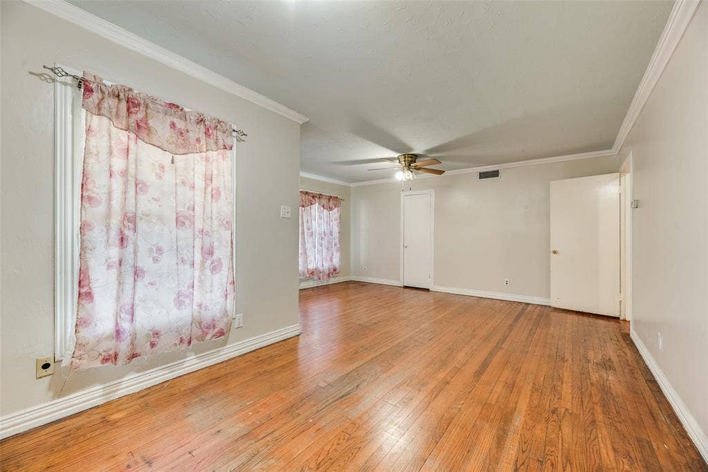 1572 Gillette Circle, Dallas, TX 75217 Wood-finish flooring, crown molding, and central ceiling fan with integrated lighting