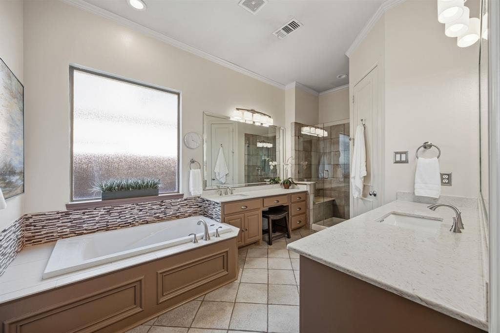 Primar bathroom with two vanities and soackign tub