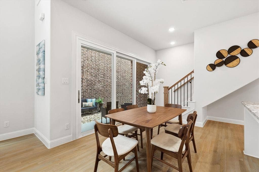 Wood-finish flooring, sliding glass door, recessed lighting, and staircase with metal balusters and wood handrail