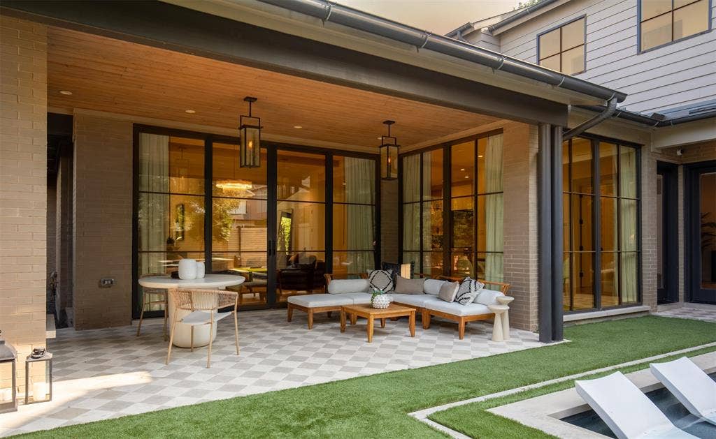 6979 Bob O Link Drive, Dallas, TX 75214 Covered patio featuring a wood-paneled ceiling, checkered stone flooring, black steel-frame glass doors, and suspended lantern-style lighting