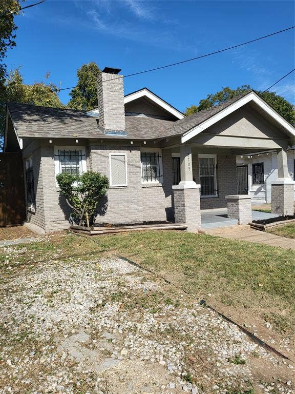 2705 Tanner Street, Dallas, TX 75215 Brick exterior featuring a covered front porch, a masonry chimney, and gable rooflines
