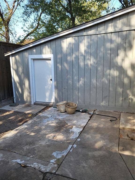 2705 Tanner Street, Dallas, TX 75215 Vertical wood-panel siding and concrete slab patio