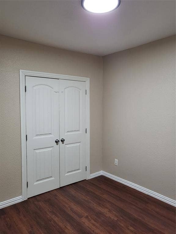 2705 Tanner Street, Dallas, TX 75215 Wood-finish flooring, white arched double-door closet, and neutral wall tones
