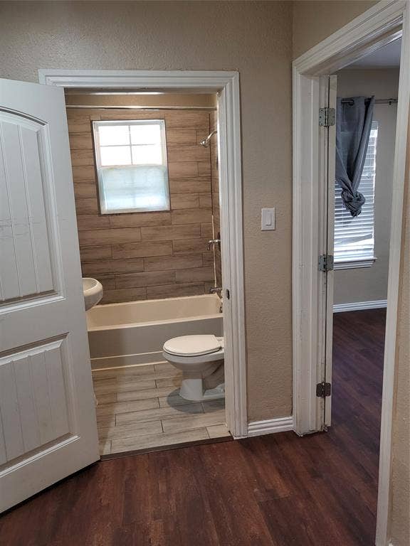 2705 Tanner Street, Dallas, TX 75215 Bathroom featuring wood-finish tile flooring, tub-shower combination with wood-finish tile surround, and wood-finish flooring in the exterior space