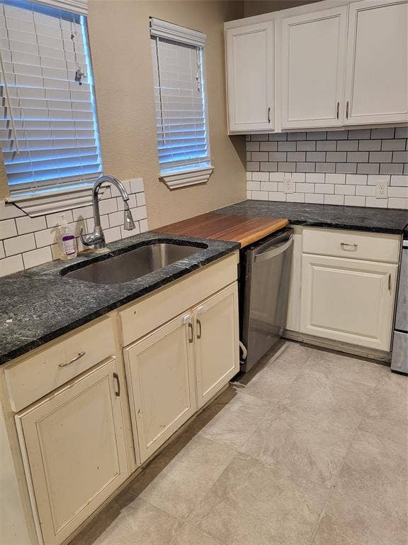 2705 Tanner Street, Dallas, TX 75215 Kitchen featuring white cabinetry, dark stone countertops, wood-finish countertop section, stainless steel under-mount sink with pull-down faucet, and subway tile backsplash