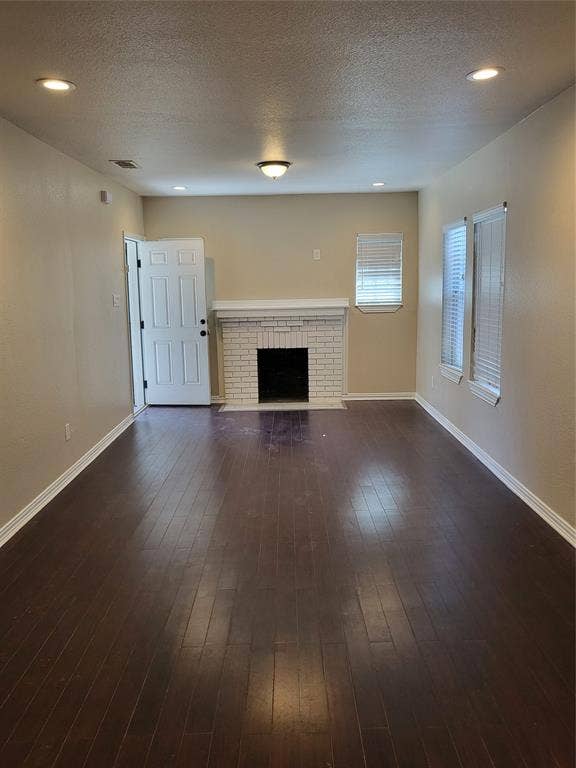 2705 Tanner Street, Dallas, TX 75215 Wood-finish flooring, white brick fireplace with a mantle, recessed ceiling lighting, and multiple windows with horizontal blinds