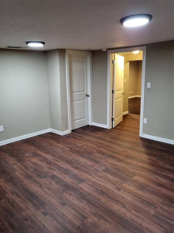2705 Tanner Street, Dallas, TX 75215 Interior space featuring dark wood-finish flooring, neutral wall paint, two-panel interior doors, and flush-mount circular lighting fixtures