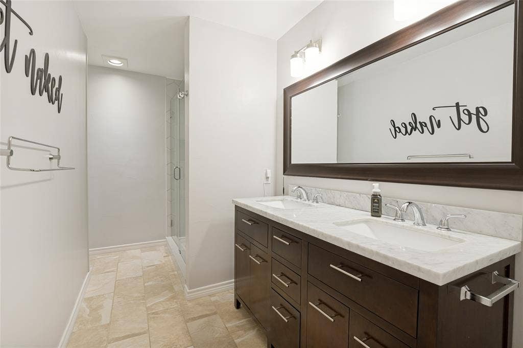 Dual sink vanity with a stone countertop and chrome fixtures
