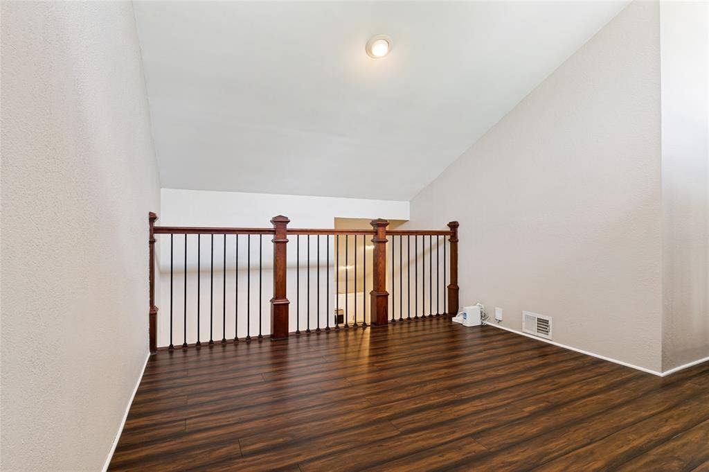 Wood-finish flooring, vaulted ceiling, recessed lighting, and wood and iron railing