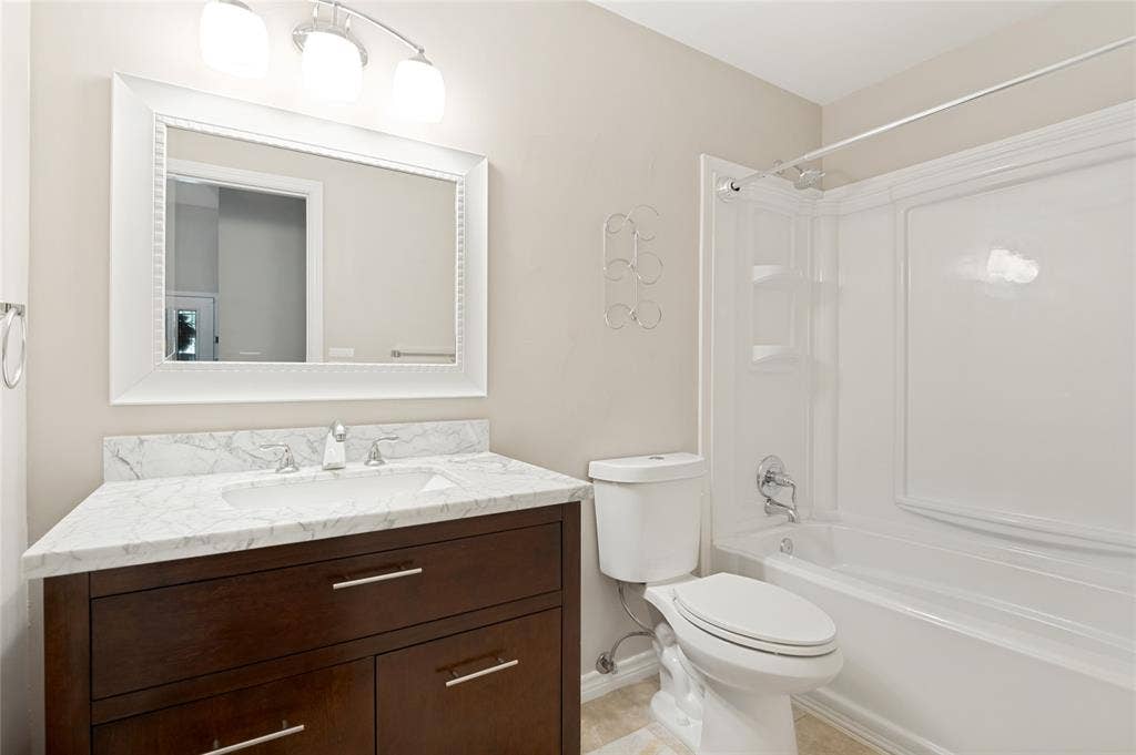 Dark wood-finish vanity with chrome hardware, an integrated sink, and a white stone-finish countertop