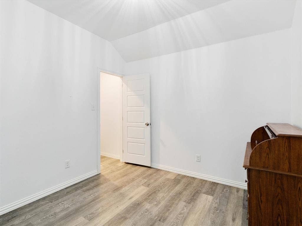 Wood-finish flooring, vaulted ceilings, and a five-panel interior door